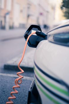 Electric car recharging with charge cable and plug leading to charge point.