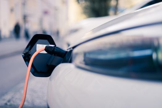 Electric car recharging with charge cable and plug leading to charge point.