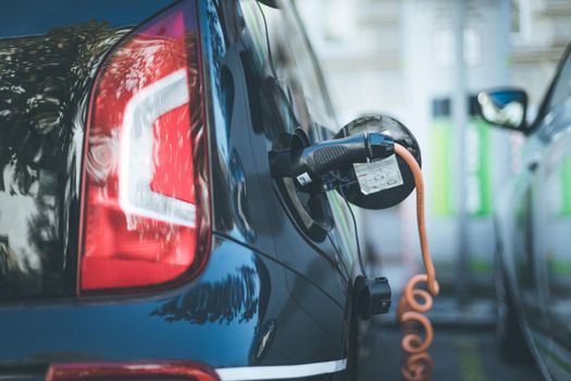 Electric car recharging with charge cable and plug leading to charge point.
