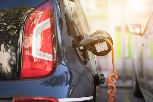 Electric car recharging with charge cable and plug leading to charge point.