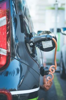 Electric car recharging with charge cable and plug leading to charge point.