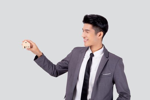 Young asian business man holding the home symbol of saving for future, insurance agent and credit, ownership house, debt and loan of finance, purchase home and refinance, investment real property.