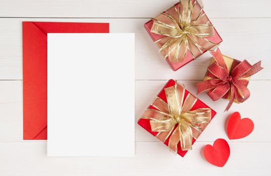 Blank postcard and letter and gift box and heart shape on wooden table, mockup greeting card and template, decoration with romantic, celebration and copy space, Valentine day and holiday concept.