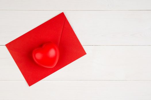 Valentine day with heart shape on red envelope on wooden desk, postcard or greeting card for congratulating, message and celebration, love and romance, top view, flat lay, holiday concept.