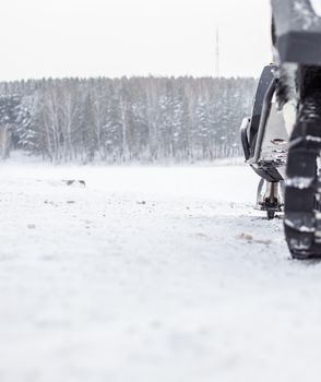 The back of the snowmobile in winter. Riding in the snow on a snowmobile. Rear suspension of a snowmobile