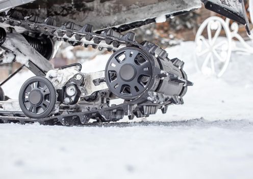 Snowmobile undercarriage in winter, close-up. Snowmobiling in the forest. Riding in the snow on a snowmobile. 
