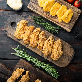 Southern fried chicken cuts on dark wooden background, top view.