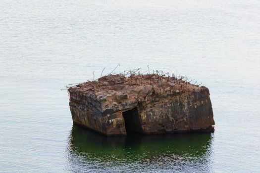 Old German bunker is rinsed out in the sea on the cliffs of the Baltic coast
