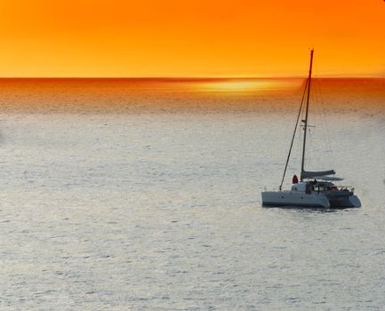 Yacht - catamaran in the tropical sea at sunset. Yachting / luxury sailing theme