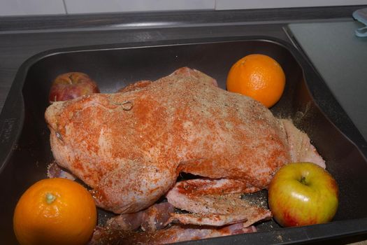 Roast goose stuffed with baked apples and oranges in a frying pan, festive Christmas recipe. Top view with copy space.