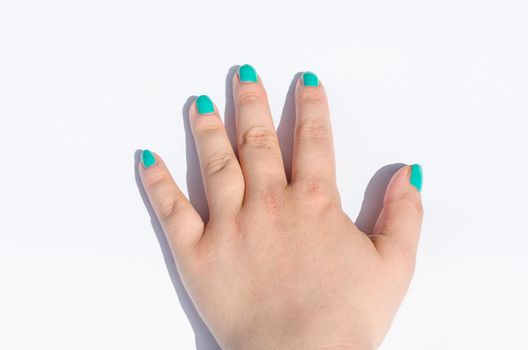 Female hand with green nail design on white background.