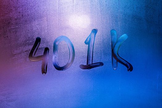 the word 401k - an employer-sponsored defined-contribution pension account plan - handwritten on night foggy window glass with purple neon street lights back light