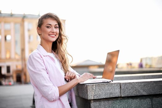 Businesswoman standing corporate building summer day using laptop Business person working remote Successful european caucasian woman freelancer make video call teacher study work online lessons