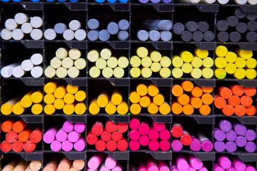 Multicolored pastel crayons art store in wooden cells. Artspace, workshop, creativity concept. Modern art. Style abstract background