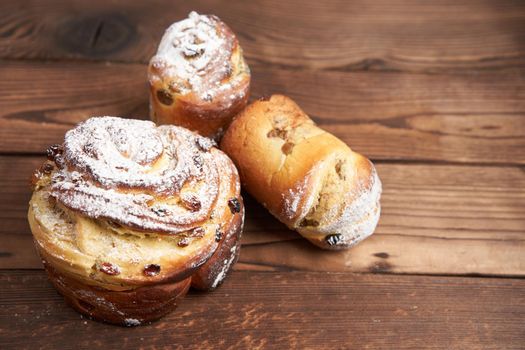 Traditional easter cake Kraffin stands on wooden table against a dark background. Spring holiday bread with copy space
