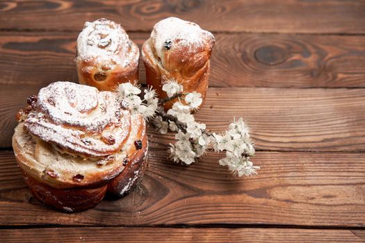 Easter cake Kraffin stands on wooden table against a dark background. Spring holiday bread with copy space