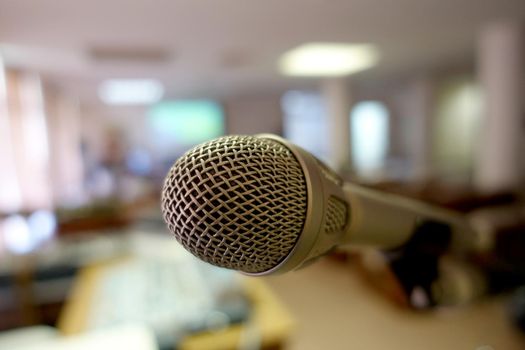 Vintage microphone over the Abstract blurred image of conference hall, study room or seminar room with attendee background, Small Business training concept, Public speaking