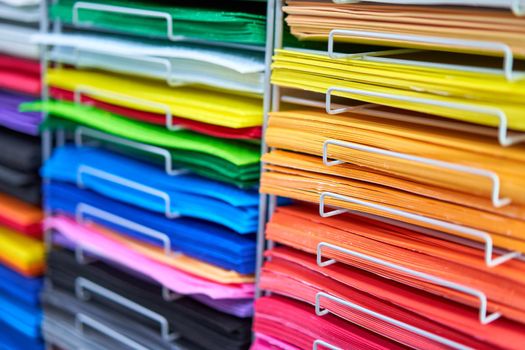 Sheets colored cardboard for designer creative works. Stacks multicolored drawing paper in the store. Colorful art papers on shelf for sale stationery store