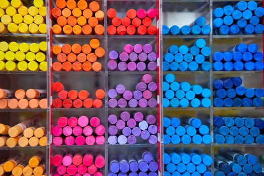 Multicolored pastel crayons art store in wooden cells. Artspace, workshop, creativity concept. Modern art. Style abstract background