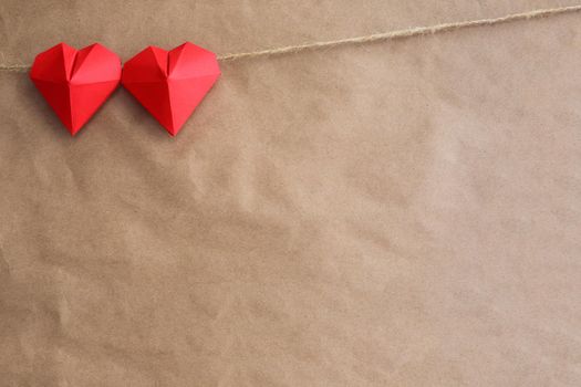 Red origami hearts on rope over paper background, Valentines day concept, copy space for text