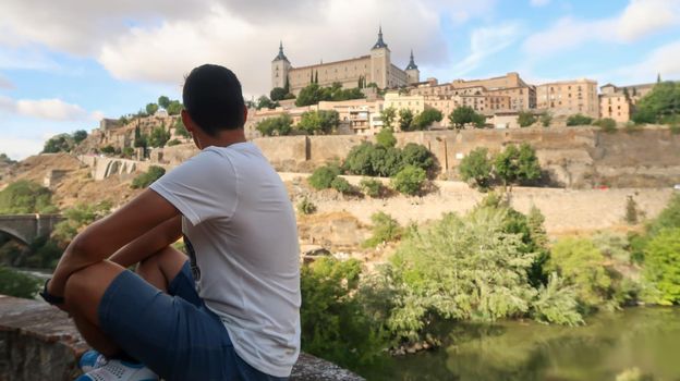 Person looking at the castle of Toledo, Spain