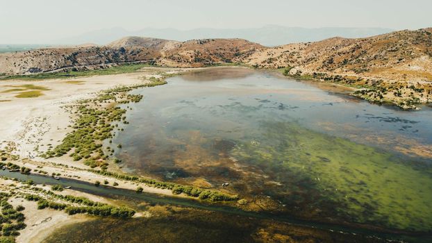 aerial drone shoot from side of an bafa lake at turkey - green is dominant color. retro looking and there is hills at background