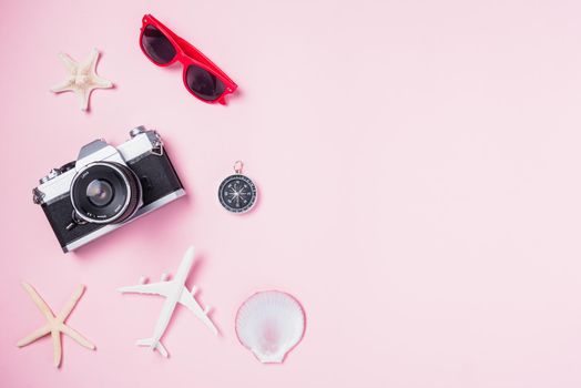 Top view flat lay mockup of retro camera films, airplane, sunglasses, starfish beach traveler accessories isolated on pink background with copy space, Business trip, and vacation summer travel concept