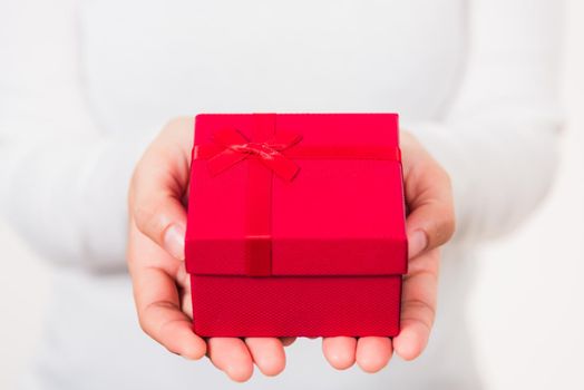 Valentine's Day. Woman beauty hands holding small gift package box present wrapped paper with ribbon isolated on white background, Birthday, New year, Christmas, holiday background concept