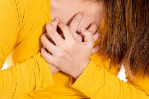 Woman touching her heart or chest isolated white background. Healthcare medical or daily life concept.