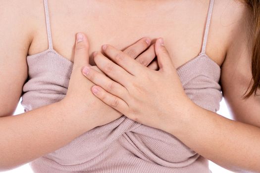 Woman touching her heart or chest isolated white background. Healthcare medical or daily life concept.