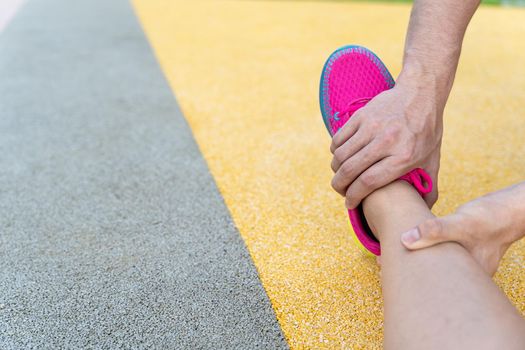 Male hand grab female leg to stretch after exercise injury.