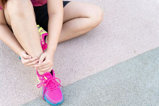 Female fatty runner athlete leg injury and pain. Hands grab painful leg while running in the park.