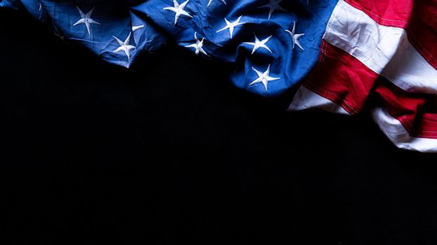 US American flag against black background. For Memorial, Presidents, Veterans, Labor, Independence or 4th of July celebration day. Top view, copy space for text.