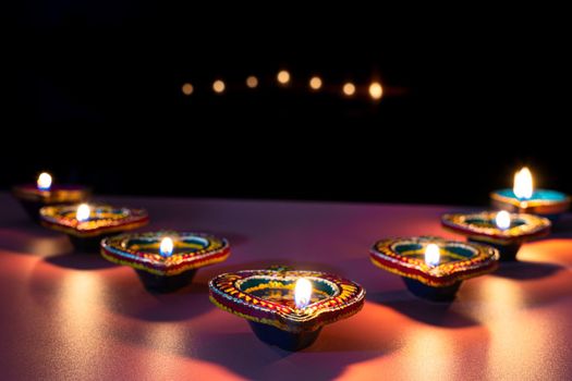 Indian festival Diwali, Diya oil lamps lit on colorful rangoli. Hindu traditional. Happy Deepavali. Copy space for text.