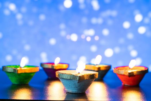 Indian festival Diwali, Diya oil lamps lit on colorful rangoli. Hindu traditional. Happy Deepavali. Copy space for text.