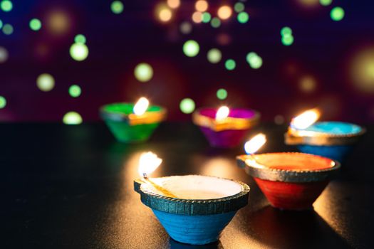 Indian festival Diwali, Diya oil lamps lit on colorful rangoli. Hindu traditional. Happy Deepavali. Copy space for text.