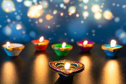 Indian festival Diwali, Diya oil lamps lit on colorful rangoli. Hindu traditional. Happy Deepavali. Copy space for text.