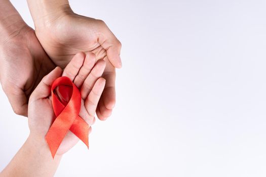 Aids awareness, man and woman hands holding red ribbon on white background with copy space for text. World Aids Day, Healthcare and medical concept.