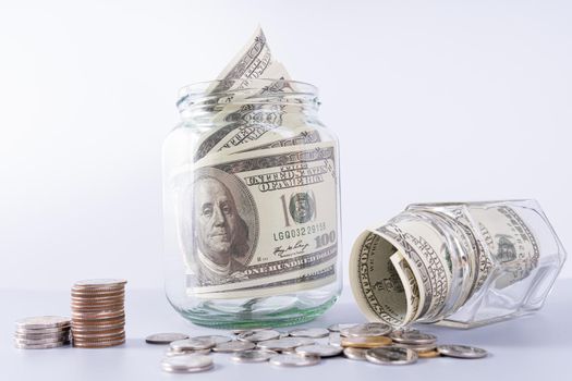 Money paper inside jar and stack coins isolated grey background. Property investment and house mortgage financial concept.