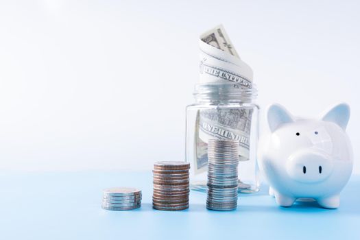 Piggy bank with stack coins and money paper inside jar isolated grey background. Property investment and house mortgage financial concept.