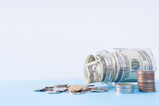 Money paper inside jar and stack coins isolated grey background. Property investment and house mortgage financial concept.