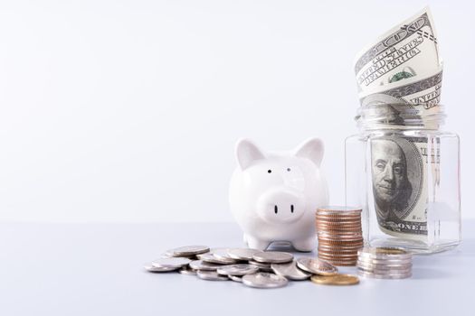 Piggy bank with stack coins and money paper inside jar isolated grey background. Property investment and house mortgage financial concept.