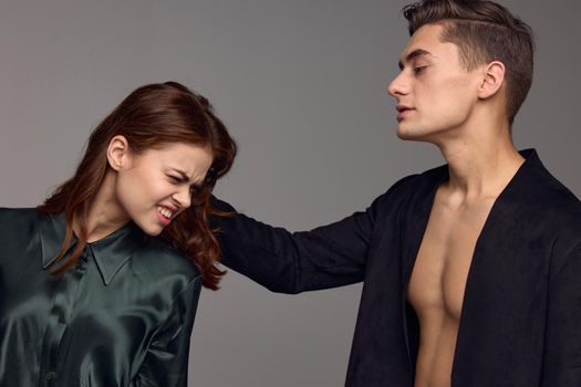 Man hurting beautiful woman on gray background aggression distrust stress. High quality photo