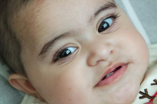 Baby girl with lovely face, big eyes and cute face gesture. Toddler baby making sweet activities