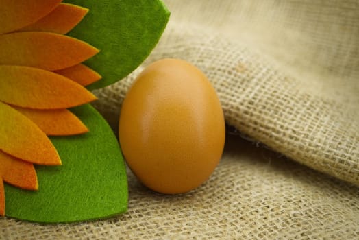 Brown raw egg on rustic hessian sack. Organic farming background with copy space
