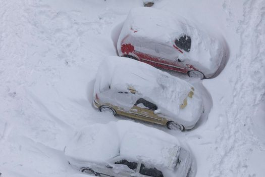 Madrid, Spain - January 09, 2021: Cars parked, blocked and completely buried by snow and ice, on a snowy day, due to the Filomena polar cold front.