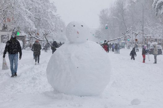 Madrid, Spain - January 09, 2021: A snowman, in the middle of Menendez Pelayo avenue, next to Retiro park, on a snowy day, due to the Filomena polar cold front.