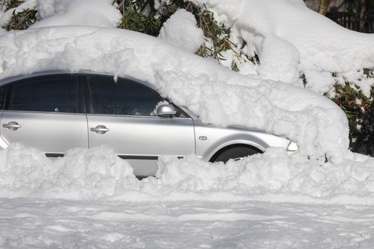 Madrid, Spain - January 10, 2021: Car parked, blocked and completely buried by snow and ice, on a snowy day, due to the Filomena polar cold front.