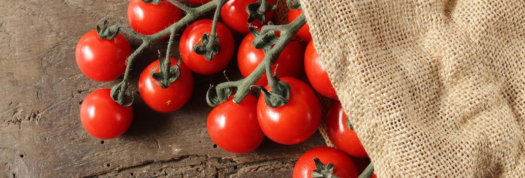 Rustic background with tomatoes, canvas bag on old wooden background. Rustic kitchen with tomatoes