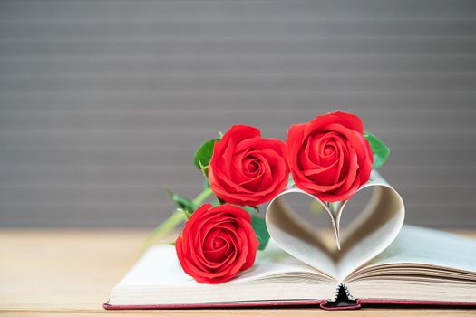 Pages of book curved into a heart shape and red rose,Love concept of heart shape from book pages